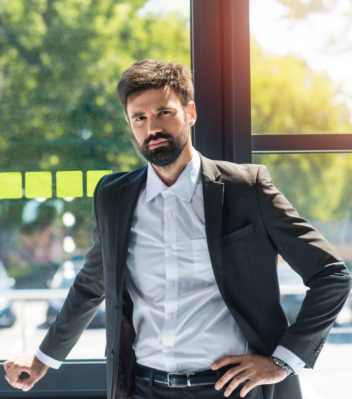 portrait-of-confident-businessman-standing-at-window-during-work